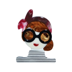 front broszki w formie dziewczyny w okrągłych czarnych okularach, z miedzianymi włosami i czerwoną opaską w odcieniach m